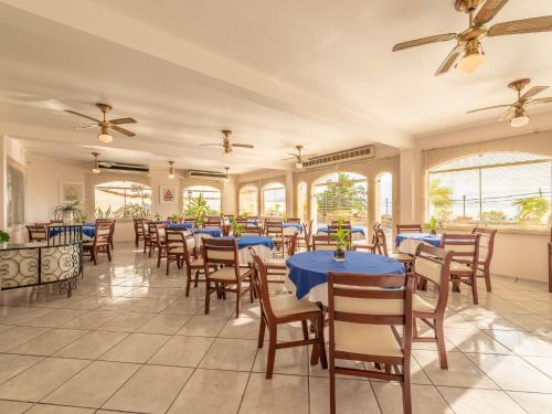 a restaurant with blue tables and chairs and windows at Hotel Guanumbis in Ilhabela