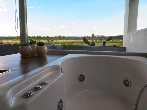 聖拉斐爾的住宿－Barrancas Suites，带窗户的浴室内的白色浴缸