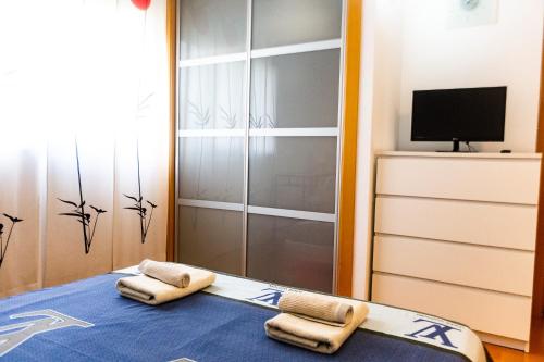a room with two towels on a bed with a television at Forum Beach in Sant Adria de Besos