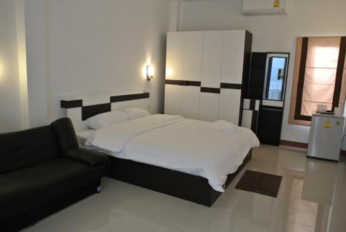 1 dormitorio con 1 cama grande y 1 sofá en Sri Samui, en Nathon