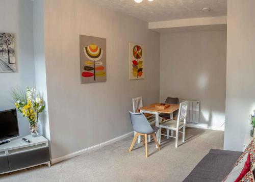 a living room with a table and chairs and a tv at Stirling Central Apartment in Stirling