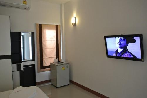 um quarto com uma televisão pendurada na parede em Sri Samui em Nathon