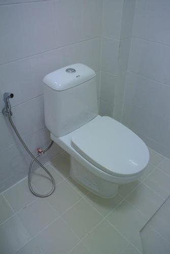 a bathroom with a toilet with a hose at Sri Samui in Nathon