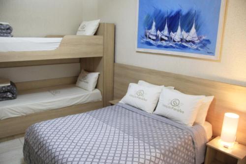 a small room with a bed and two bunk beds at Hotel Estação Paraíso - ao lado do Metrô Paraíso e 600m da Av Paulista in Sao Paulo