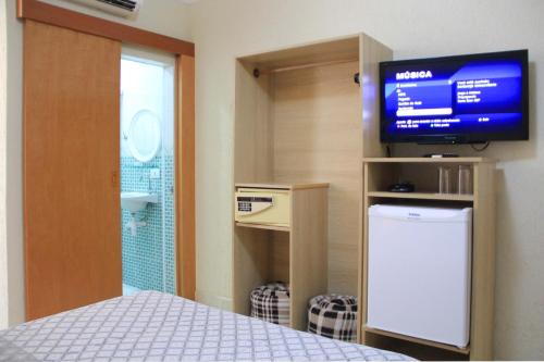 a bedroom with a bed and a tv in a room at Hotel Estação Paraíso - ao lado do Metrô Paraíso e 600m da Av Paulista in Sao Paulo