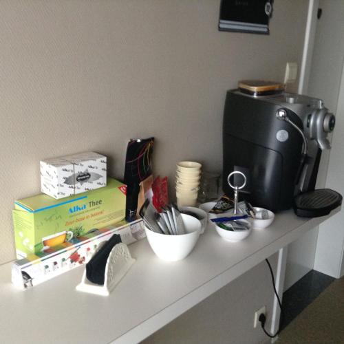a counter with a coffee maker and a bowl of utensils at Guesthouse De Steenberg tweepersoonskamer met grote badkamer, kitchenette en tuinzicht op de eerste verdieping in Geel
