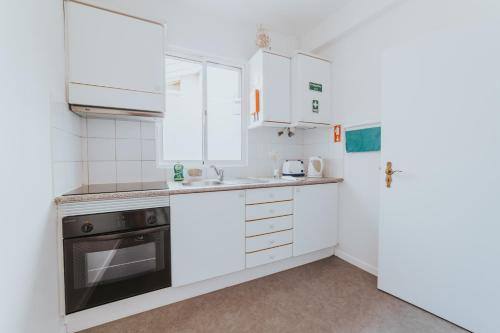 a kitchen with white cabinets and a refrigerator at Old City Apartment in Funchal