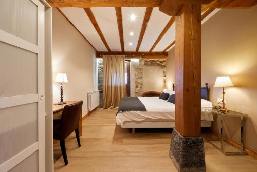 Pokój hotelowy z łóżkiem i biurkiem oraz łóżkiem o wymiarach sześciu sześciu sześciu. w obiekcie URAIN Suites - Apartments at Flysch-Coast w mieście Zumaia