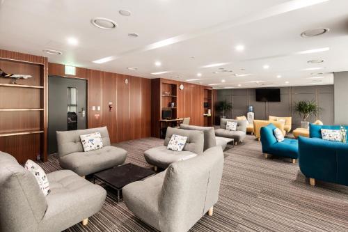 a waiting room with couches and chairs and a television at Golden Tulip Incheon Airport Hotel in Incheon