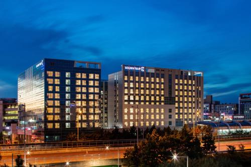 a lit up building in a city at night at Golden Tulip Incheon Airport Hotel in Incheon