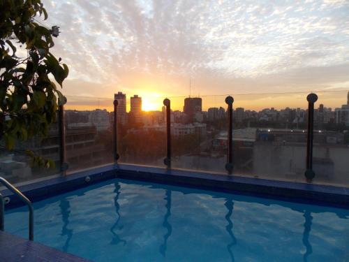 una piscina en la azotea de un edificio con puesta de sol en Bosques & Lagos Palermo en Buenos Aires