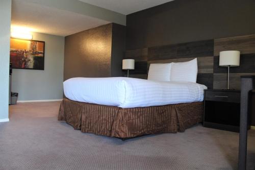 a bedroom with a large bed with white sheets and pillows at Cozy Inn in Costa Mesa