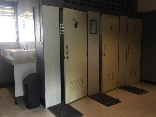 a row of stalls in a bathroom with a sink at KC guest house in Bangkok