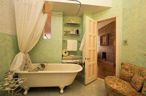 Habitación con baño con bañera blanca. en Harlem Grand en Nueva York