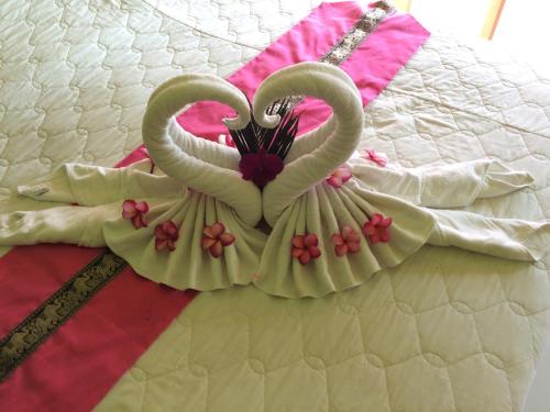 two swans shaped like hearts sitting on a bed at Cookies Hotel in Ko Chang