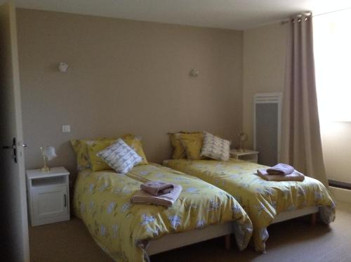 a bedroom with two beds with towels on them at Auberge de la vallee de la gorre in Saint-Auvent