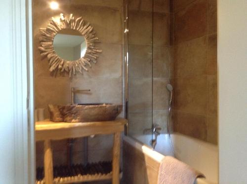 uma casa de banho com um lavatório, um espelho e uma banheira em Auberge de la vallee de la gorre em Saint-Auvent