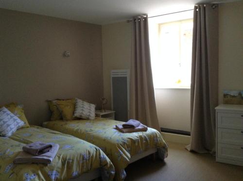a bedroom with two beds and a window at Auberge de la vallee de la gorre in Saint-Auvent