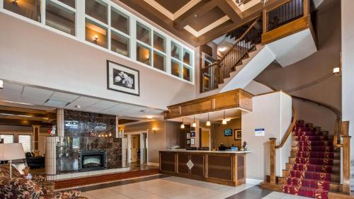 a large lobby with a staircase and a fireplace at Best Western Williams Lake in Williams Lake