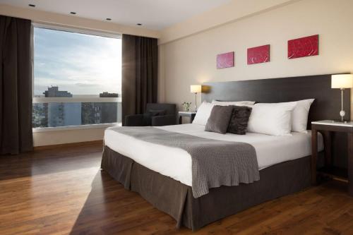 Кровать или кровати в номере Dazzler by Wyndham Puerto Madryn