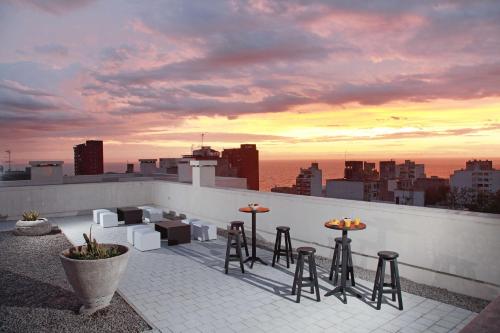 un bar en la azotea con taburetes y vistas a la ciudad en Esplendor by Wyndham Montevideo Cervantes, en Montevideo