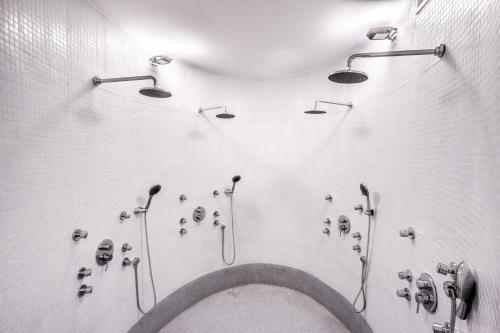 a bathroom with many shower heads on the wall at Dazzler by Wyndham Colonia in Colonia del Sacramento