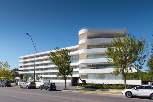 a white building with cars parked in front of it at Dazzler by Wyndham Colonia in Colonia del Sacramento