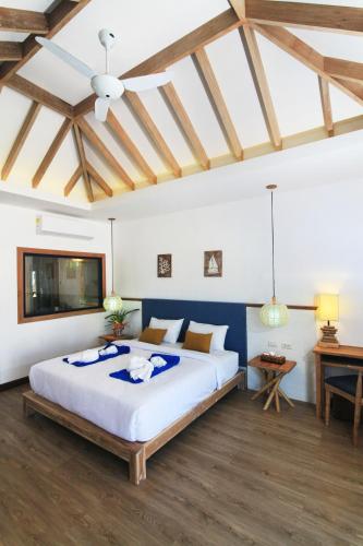 a bedroom with a large bed and a television at Lanta Casa Blanca in Ko Lanta