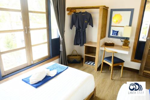 a bedroom with a bed and a shirt hanging on the wall at Lanta Casa Blanca in Ko Lanta
