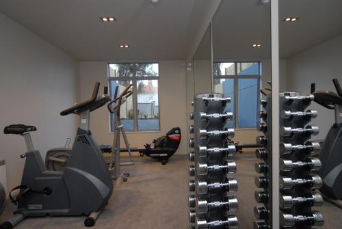 a gym with treadmills and ellipticals in a room at Bluestone On George in Dunedin