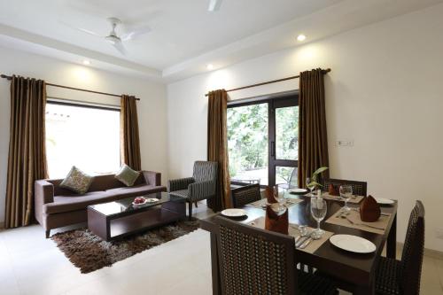 a living room with a dining table and a couch at The Riverview Retreat Corbett by Leisure Hotels in Garjia