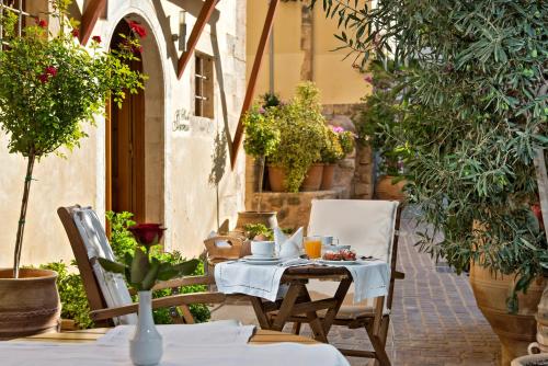 a table and chairs on a patio with plants at Ionas Boutique Hotel in Chania Town