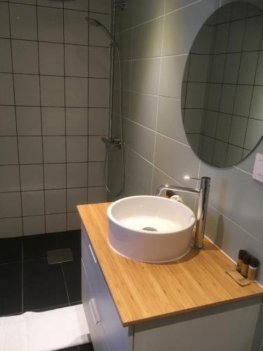 La salle de bains est pourvue d'un lavabo blanc et d'une douche. dans l'établissement Dharma City, à Florennes