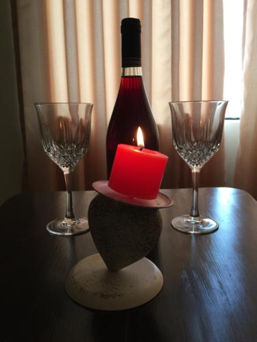 una candela e due bicchieri di vino su un tavolo di Suites El Parque a Lima