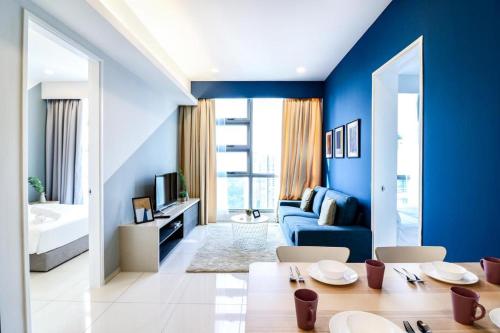 sala de estar con paredes azules y sofá azul en Apex Cozy Suites at Swiss Garden Residence Kuala Lumpur, en Kuala Lumpur