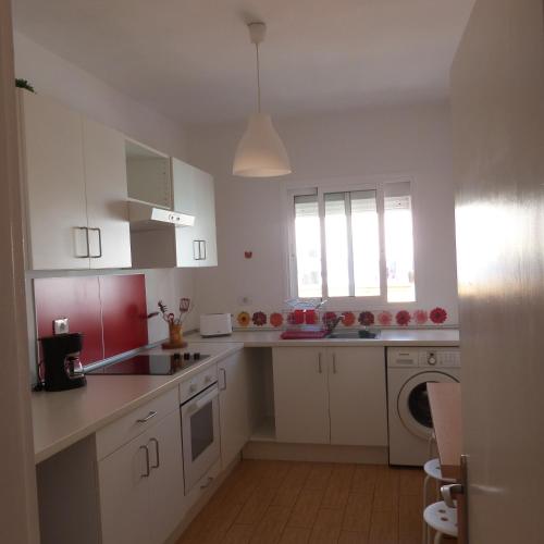 a kitchen with white cabinets and a washer and dryer at Pepe y Nina in Las Lagunas