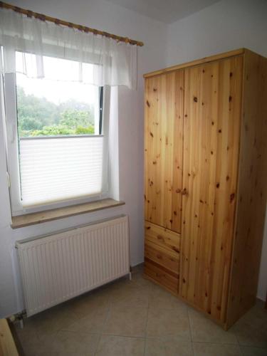 a room with a wooden cabinet and a window at Ferienwohnung Scholz in Lühmannsdorf