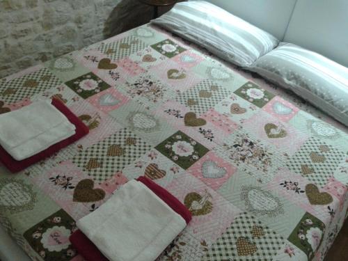 a bed with a quilt and two towels on it at Lilla B&B in Molfetta