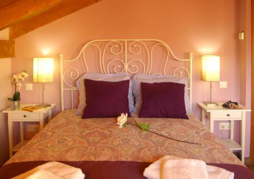ein Schlafzimmer mit einem großen Bett mit lila Kissen in der Unterkunft La Casita de Adanero in Adanero