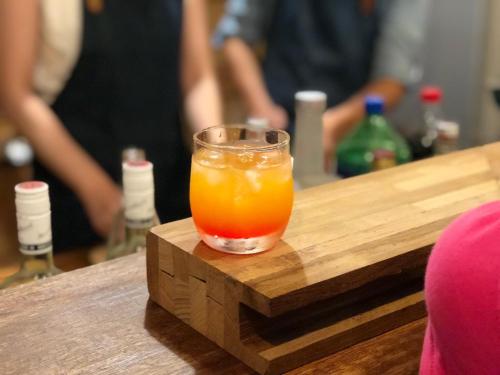 a glass of orange juice sitting on a wooden table at Old Man Captain in Tainan