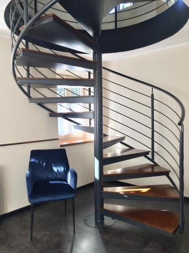 a blue chair next to a spiral staircase at Stanzl Haus in Kaltenbach