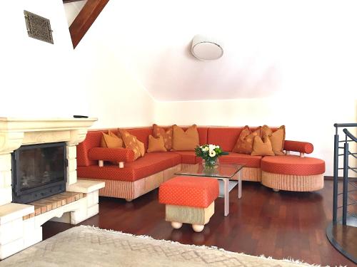 a living room with a red couch and a fireplace at Stanzl Haus in Kaltenbach