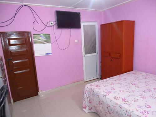 a bedroom with a bed and a pink wall at Manjula Luxury Apartment in Negombo