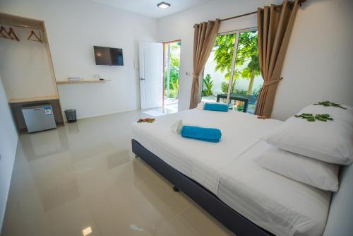 1 dormitorio con 1 cama grande con sábanas blancas y almohadas azules en Lagoon Villa Thoddoo, en Thoddoo