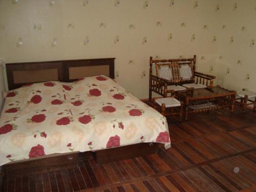 ein Schlafzimmer mit einem Bett, einem Stuhl und einem Tisch in der Unterkunft Hotel Today , Խաղաղության լողափ in Shorzha