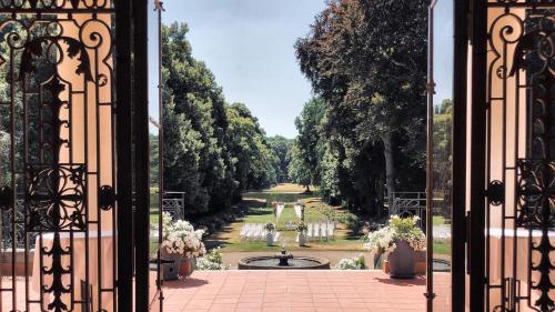an open gate with a view of a garden at Hotel Schloss Teutschenthal in Teutschenthal