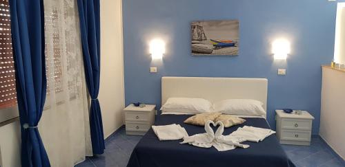 a blue bedroom with a bed with towels on it at 100 passi dal mare in Agropoli