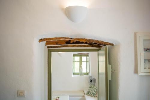a bathroom with a mirror and a sink at Perivoli House in Mylopotas