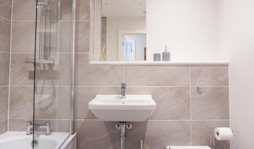 La salle de bains est pourvue d'un lavabo, de toilettes et d'une douche. dans l'établissement Stones Throw, à Newquay