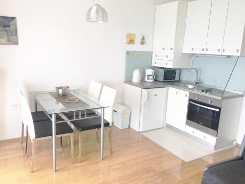 a kitchen with white cabinets and a table and chairs at Apartment Sol - 5m from the sea in Drasnice